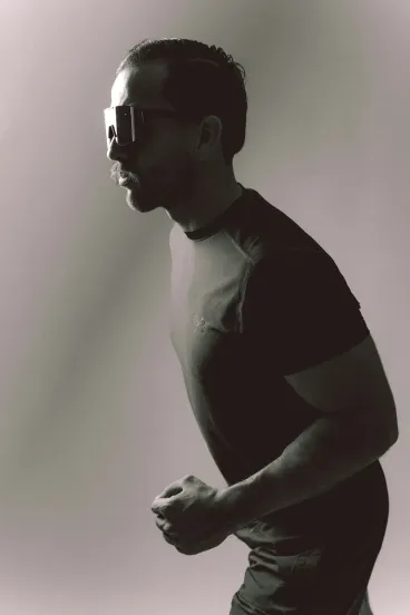 A man in running gear in side profile, catching his breath